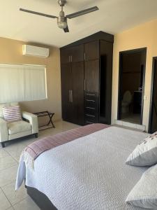 a bedroom with a bed and a cabinet and a chair at Beach house in San Miguel, Ensenada in Ensenada