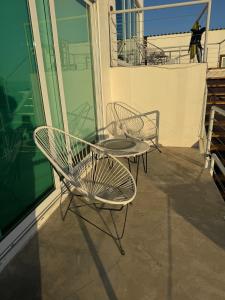 a patio with two chairs and a table on a balcony at Beach house in San Miguel, Ensenada in Ensenada +20 photos
