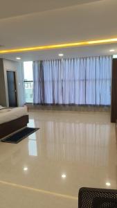 a bedroom with a bed and a window with curtains at Sri Krishna Residency in Tirupati