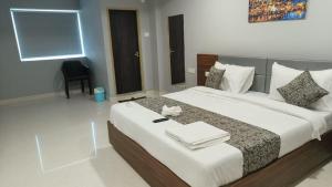 a bedroom with a large bed with towels on it at Sri Krishna Residency in Tirupati