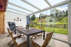a conservatory with a table and chairs on a patio at Haus Anna in Kirchberg in Tirol +9 photos