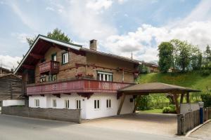 a large wooden house with a porch at Haus Anna in Kirchberg in Tirol