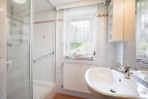 a white bathroom with a sink and a shower at Haus Anna in Kirchberg in Tirol