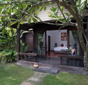 a room with a bed and a table and a tree at Mali Resort Pattaya Beach Koh Lipe in Ko Lipe