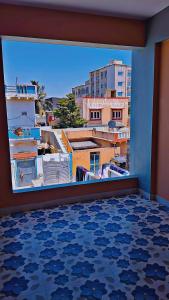 a room with a view of a city from a window at Radhe House in Dwarka