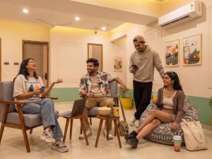 a group of people sitting in chairs in a room at The Hosteller Gurgaon in Gurgaon
