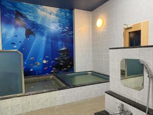 a bathroom with an aquarium with a large painting at Capsule Inn Kinshicho in Tokyo
