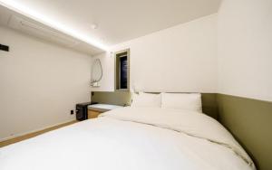 a bedroom with a white bed and a window at 넘버25 신촌점 in Seoul