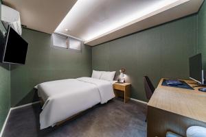 a bedroom with a large white bed and a desk at 넘버25 신촌점 in Seoul