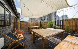 a patio with a wooden table and chairs on a deck at 넘버25 신촌점 in Seoul