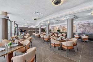 a restaurant with tables and chairs in a room at Boutique Hotel Opal ULTRA ALL INCLUSIVE in Sunny Beach