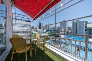 a balcony with tables and chairs and a view of a city at From H Dongbaek Hotel by Kwon Gohyeon in Geoje