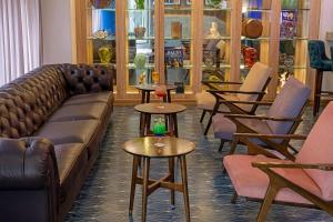 a living room with a couch and tables and chairs at Faranda Collection Cali, a member of Radisson Individuals in Cali