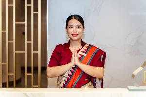 a woman holding her hands up in front of a mirror at Jiuding Joy Hotel in Kathmandu