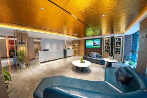 a lobby with a couch and a table and a tv at Jiuding Joy Hotel in Kathmandu