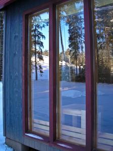 a window of a house with snow on the ground at Kempings Ozolkalns in Cēsis