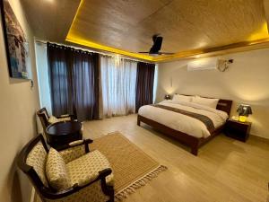 a bedroom with a bed and a chair in it at Meechung Resort in Skardu