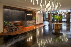 a lobby with a table and chairs and a chandelier at Hotel 1000, In The Unbound Collection By Hyatt in Seattle