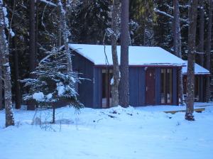 a cabin in the woods with snow on it at Kempings Ozolkalns in Cēsis