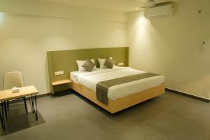 a bedroom with a large bed and a small table at Hotel The Nature Regency in Satara