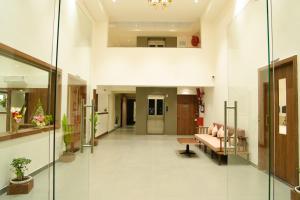 a hallway of a hospital with a couch and a chair at Hotel The Nature Regency in Satara +16 photos