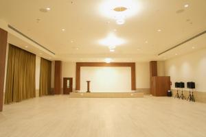 a large room with a stage and a white screen at Hotel The Nature Regency in Satara