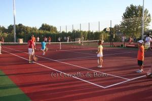 a group of children standing on a tennis court at Apartamento playa in Boiro +11 photos