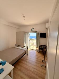 a bedroom with a bed and a sliding glass door at Rosalie Home - Aegean Poseidon in Tinos
