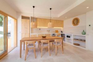 a large kitchen with a wooden table and chairs at Sa Font in Puigpunyent +43 photos