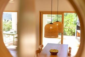 a dining room with a wooden table and two hanging lights at Sa Font in Puigpunyent