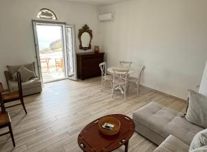 a living room with a couch and a table at Rosalie Home - Aegean Poseidon in Tinos