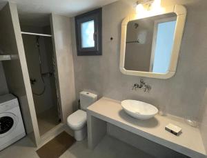 a bathroom with a sink and a toilet and a mirror at Rosalie Home - Aegean Poseidon in Tinos +12 photos