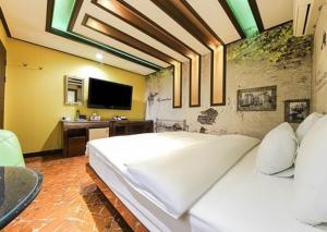 a large white bed in a room with a tv at Hotel I Chuncheon Branch in Chuncheon