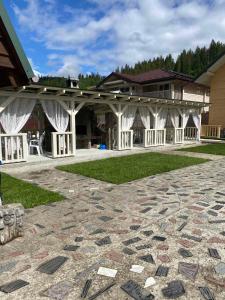 ein Gebäude mit einem Pavillon und einer Steinterrasse in der Unterkunft Pogar White in Slawske