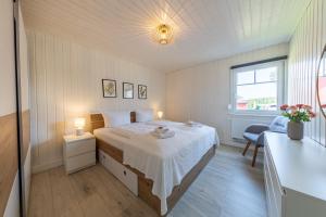 a bedroom with a bed and a window and a table at Ferienhaus Hafenoase in Wandlitz