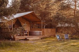 a tent with a tub and a table and chairs at Kwiejcówka in Kwiejce