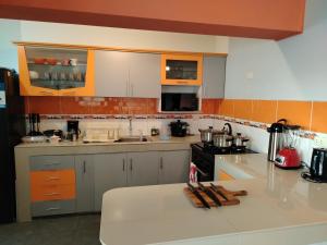 a kitchen with a white counter top and orange at Alojamiento Wanka in Huancayo