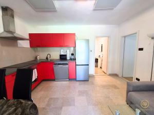 a kitchen with red cabinets and a refrigerator at Riverside Apartments - pet friendly in Sečovlje