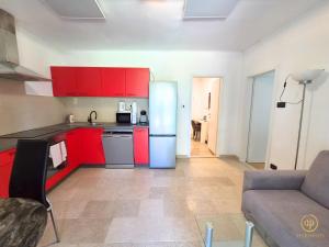 a kitchen with red cabinets and a couch in a room at Riverside Apartments - pet friendly in Sečovlje +84 photos