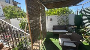 a patio with chairs and a table and a fence at Home Star 2 in Dāliyat el Karmil