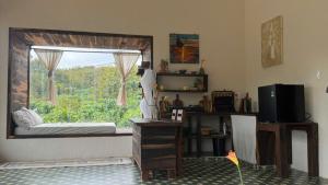 a room with a window with a bed and a desk at Đồi Ông Thoại Cottage in Bảo Lộc