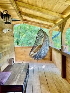 a hammock hanging in a room in a cabin at Bat's Cave Hut Transylvania - Rustic Retreat in Sub Piatra