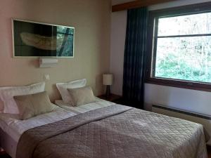 a bedroom with a large bed and a window at Kylpyla SPA, Saimaa Villa B3 in Imatra