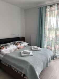 a bedroom with a bed with two towels on it at LUX Apartament Rogowo Pearl in Rogowo +13 photos