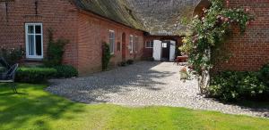 a courtyard of a brick building with a wreath of flowers at Hof Döttgebüll in Aventoft