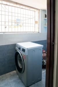 a washing machine in a room with a window at My3 Dwarkamai in Vijayawāda