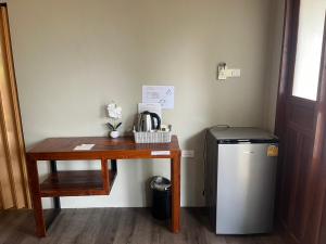 a small desk with a table next to a refrigerator at Slow Life Sabaidee Pai in Pai