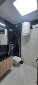 a bathroom with a toilet and a sink at Infinity Studio, Shkorpilovtsi in Shkorpilovtsi +11 photos