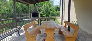 a wooden picnic table with a grill on a patio at Infinity Studio, Shkorpilovtsi in Shkorpilovtsi