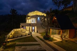 a house with a lit up facade at night at Green Infinity Resorts in Diyatalawa